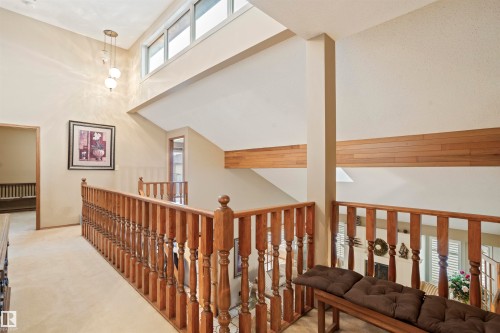 Spacious multi-level interior featuring a wood spindle railing, neutral carpeting, and high ceilings - 9831 158 Avenue, Edmonton, AB - Indoor Photo Showing Other Room