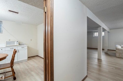 Finished lower level with wood-finish flooring, white cabinetry, and recessed windows - 9831 158 Avenue, Edmonton, AB - Indoor