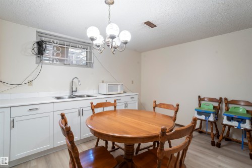 White cabinetry with an integrated double basin sink, light countertops, and a full backsplash - 9831 158 Avenue, Edmonton, AB - Indoor Photo Showing Dining Room