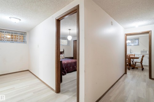 Interior space featuring light wood-finish flooring, white walls, and dark wood trim - 9831 158 Avenue, Edmonton, AB - Indoor Photo Showing Other Room