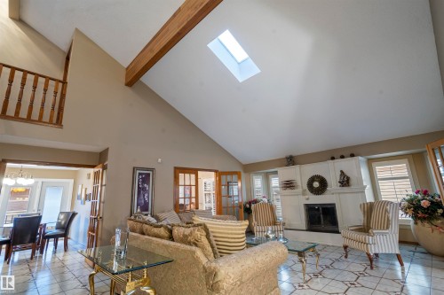 Vaulted ceiling featuring a skylight and exposed wood beam - 9831 158 Avenue, Edmonton, AB - Indoor Photo Showing Living Room With Fireplace