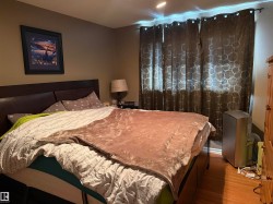 Bedroom featuring hardwood floors and dark curtains - 