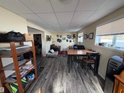 Spacious room featuring wood-style flooring, a window with blinds, and recessed lighting - 