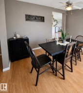Dining area featuring light-toned flooring, a ceiling fan with integrated lighting, and neutral wall tones - 