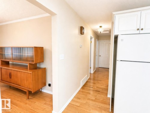Hardwood-finish flooring throughout, complemented by light neutral wall tones and white baseboards - 11139 30 Avenue, Edmonton, AB - Indoor Photo Showing Other Room