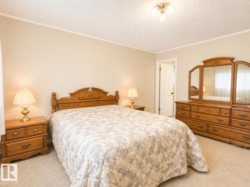 Bedroom featuring neutral wall paint, light carpeting, and a three-bulb ceiling light fixture - 11139 30 Avenue, Edmonton, AB - Indoor Photo Showing Bedroom