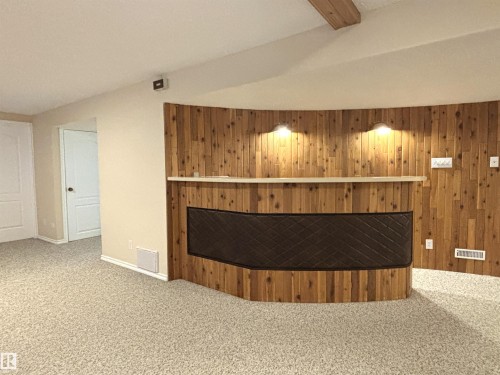 Custom-built wooden bar with integrated shelving and accent lighting, featuring an upholstered front panel - 11139 30 Avenue, Edmonton, AB - Indoor Photo Showing Other Room