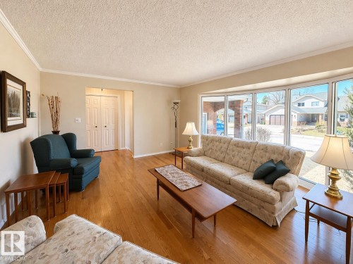 Hardwood flooring, crown molding, and neutral wall tones define this living space - 11139 30 Avenue, Edmonton, AB - Indoor Photo Showing Living Room