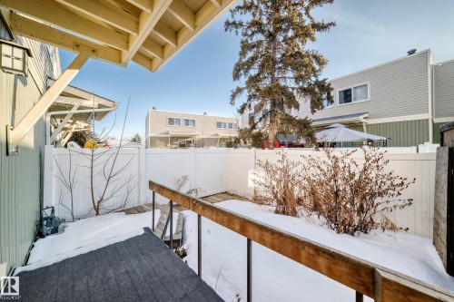 The property features a fenced yard with a small deck and a gas meter on the exterior wall - 8217 182 Street Nw, Edmonton, AB - Outdoor