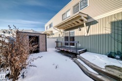 The property features an exterior deck with wooden stairs and an awning, and an outdoor storage shed - 