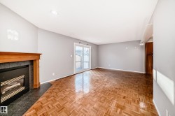 Living area featuring parquet wood flooring, a fireplace with a wood mantel and dark tile surround, and sliding glass doors - 