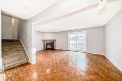 Living area featuring parquet wood flooring, a fireplace with a wood mantle and dark tile surround, and a sliding glass door - 