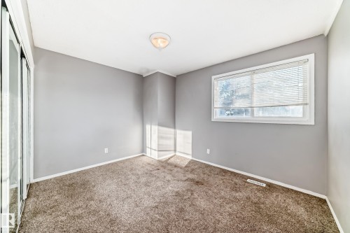 This room features carpeted flooring, light grey walls, and a window with blinds - 8217 182 Street Nw, Edmonton, AB - Indoor Photo Showing Other Room