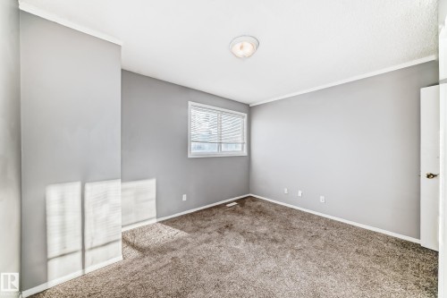 This room features a window with blinds, light gray walls, white trim, and a ceiling light fixture - 8217 182 Street Nw, Edmonton, AB - Indoor Photo Showing Other Room