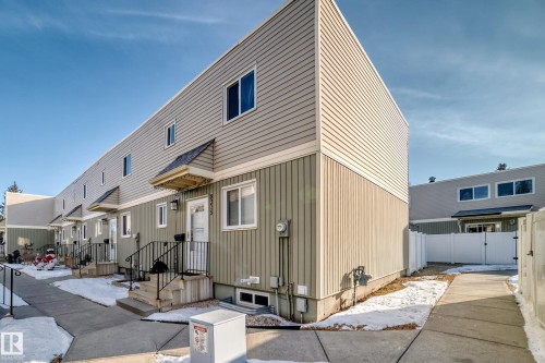 This property features a two-story exterior with light-colored siding on the upper portion and a contrasting darker tone on the lower portion - 8217 182 Street Nw, Edmonton, AB - Outdoor