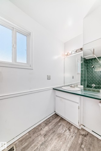 Bathroom featuring a white vanity with a light green countertop and a large mirror - 8217 182 Street Nw, Edmonton, AB - Indoor Photo Showing Bathroom