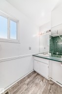 Bathroom featuring a white vanity with a light green countertop and a large mirror - 