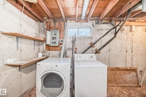 The utility area features a clothes washer and dryer, a window, and exposed wooden shelving - 8217 182 Street Nw, Edmonton, AB - Indoor Photo Showing Laundry Room