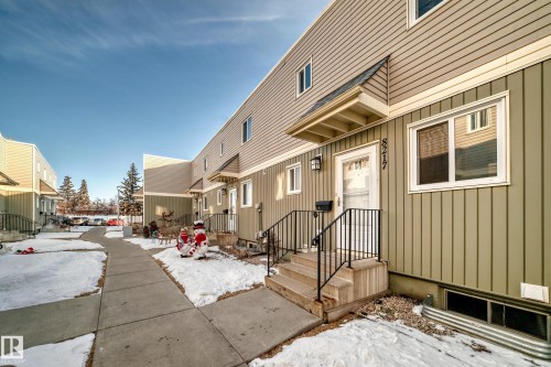 The property features an exterior with light green vertical siding and horizontal siding, along with white window frames and a covered front entry - 8217 182 Street Nw, Edmonton, AB - Outdoor