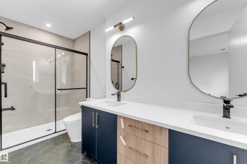 Bathroom featuring a dual vanity with white countertops, integrated sinks, and matte black faucets - 7934 77 Avenue, Edmonton, AB - Indoor Photo Showing Bathroom