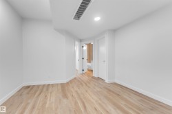 Bright room featuring wood-finish flooring and white baseboards - 