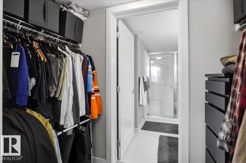 This property features a walk-in closet with built-in shelving, hanging rods, and storage cubes - 211 5029 Edgemont Boulevard, Edmonton, AB - Indoor With Storage