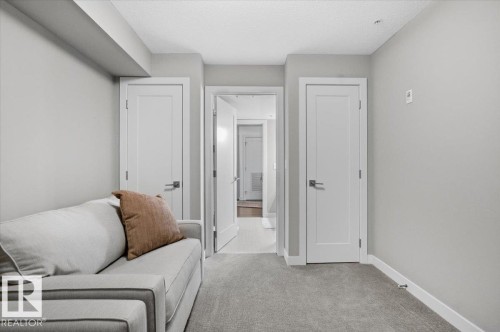 Interior room featuring light gray walls, white trim, and gray carpet flooring - 211 5029 Edgemont Boulevard, Edmonton, AB - Indoor