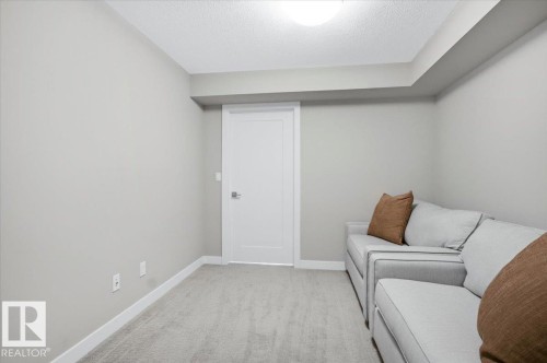 This room features light grey walls and light grey carpeting, creating a neutral and inviting atmosphere - 211 5029 Edgemont Boulevard, Edmonton, AB - Indoor Photo Showing Other Room