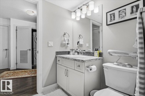 Bathroom featuring a vanity with a white cabinet, a light-colored countertop, and a tiled backsplash - 211 5029 Edgemont Boulevard, Edmonton, AB - Indoor Photo Showing Bathroom
