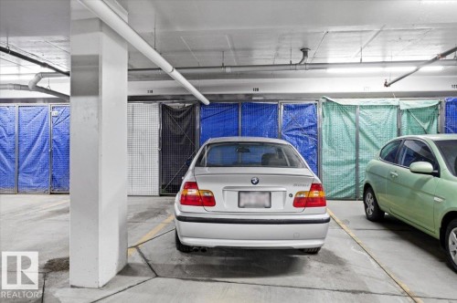 This property includes a designated parking space within a garage, providing convenient vehicle accommodation - 211 5029 Edgemont Boulevard, Edmonton, AB - Indoor Photo Showing Garage