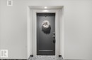 The property features a modern dark gray entrance door with white trim, complemented by a recessed light overhead - 211 5029 Edgemont Boulevard, Edmonton, AB  -  Photo Showing Other Room 