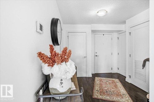 Entryway featuring dark wood flooring, white walls, and white doors - 211 5029 Edgemont Boulevard, Edmonton, AB - Indoor Photo Showing Other Room