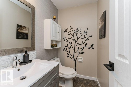Contemporary bathroom featuring a vanity with a rectangular sink, chrome faucet, and mosaic tile backsplash - 1727 65 Street, Edmonton, AB - Indoor Photo Showing Bathroom