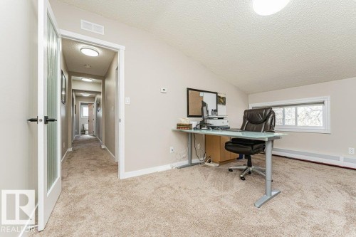 Carpeted room with a vaulted ceiling and an integrated window - 1727 65 Street, Edmonton, AB - Indoor Photo Showing Office
