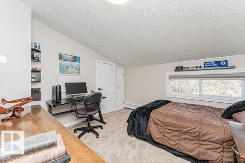 Bedroom featuring a sloped ceiling, light-toned carpeting, and a window with a white frame - 1727 65 Street, Edmonton, AB - Indoor Photo Showing Bedroom