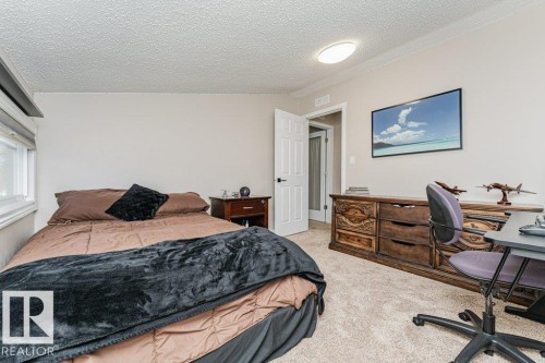 Carpeted room with a window, white paneled door, and a flush-mount ceiling light fixture - 1727 65 Street, Edmonton, AB - Indoor Photo Showing Bedroom