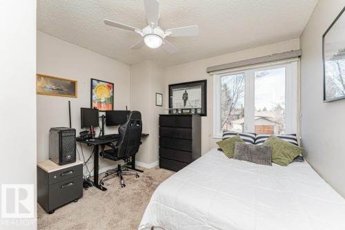 Carpeted room with a ceiling fan, a window, and neutral wall paint - 1727 65 Street, Edmonton, AB - Indoor Photo Showing Bedroom