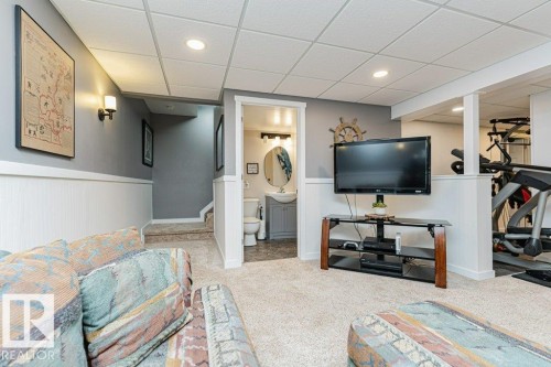 Carpeted entertainment area featuring recessed lighting and wainscoting - 1727 65 Street, Edmonton, AB - Indoor