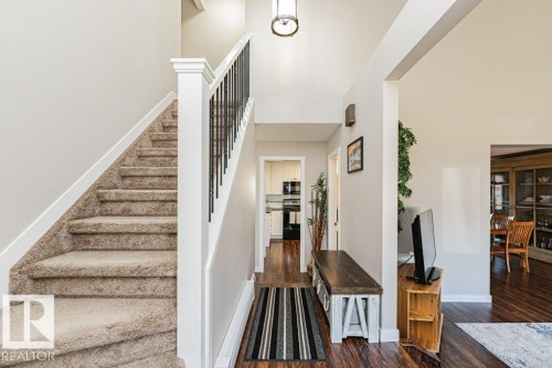 Two-story foyer with a vaulted ceiling and a drum pendant light fixture - 1727 65 Street, Edmonton, AB - Indoor Photo Showing Other Room