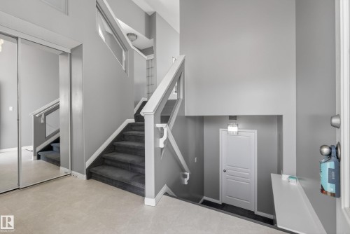 Carpeted staircase with white railings, featuring light grey walls throughout - 720 87 Street, Edmonton, AB - Indoor Photo Showing Other Room