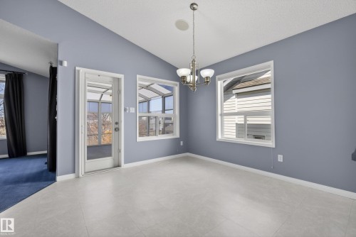 Bright room with light gray tile flooring and a vaulted ceiling - 720 87 Street, Edmonton, AB - Indoor Photo Showing Other Room