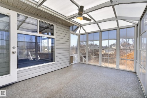 Enclosed sunroom featuring a translucent vaulted ceiling, ceiling fan with integrated lighting, and multiple large windows - 720 87 Street, Edmonton, AB - Outdoor
