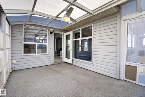Enclosed patio featuring a translucent panel roof, ceiling fan with integrated lighting, textured floor, and a French door entry - 720 87 Street, Edmonton, AB - Outdoor With Exterior