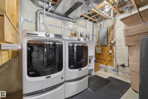 Utility area featuring exposed ceiling joists and various piping - 720 87 Street, Edmonton, AB - Indoor Photo Showing Laundry Room