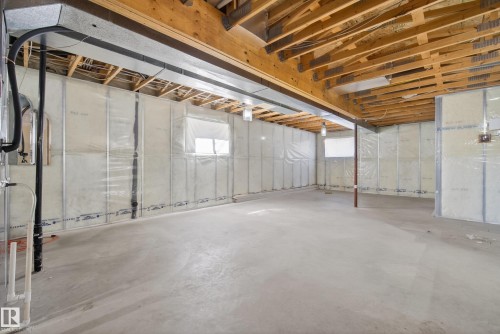 Unfinished lower level with exposed ceiling joists and concrete flooring - 720 87 Street, Edmonton, AB - Indoor Photo Showing Basement