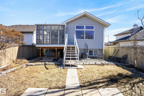 Rear exterior featuring a screened-in porch, elevated wood deck, and a full set of exterior stairs - 720 87 Street, Edmonton, AB - Outdoor