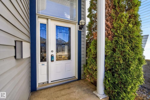 White entrance door with decorative glass inserts, transom window, and a sidelight - 720 87 Street, Edmonton, AB - Outdoor With Exterior