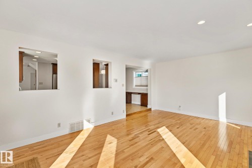 This spacious room features hardwood floors, recessed lighting, and white walls - 10823 130 Street, Edmonton, AB - Indoor Photo Showing Other Room