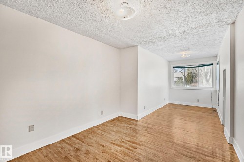 The interior features light wood flooring and white walls, with a window providing natural light - 10823 130 Street, Edmonton, AB - Indoor Photo Showing Other Room