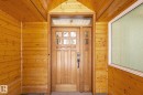 The property features a wooden entry door with glass panels, complemented by natural wood paneling on the walls and ceiling - 10823 130 Street, Edmonton, AB  - Indoor Photo Showing Other Room 